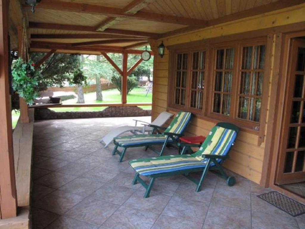 巴尔切沃Szypry - wakacyjny dom nad jeziorem的庭院设有3把草坪椅和门廊。