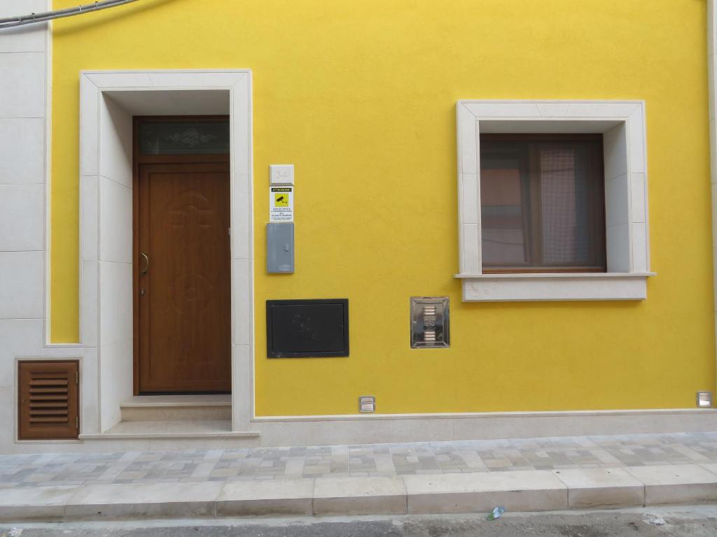 曼杜里亚Casa Rita的黄色的建筑,有门和窗户