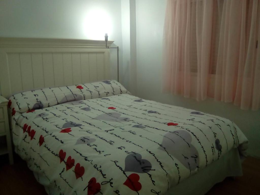 马德里Apartamentos pandiellos I的一张床上的毯子,上面有红色的鲜花