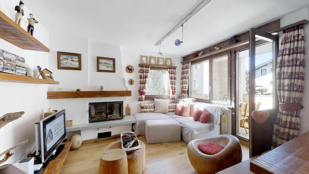 锡尔斯玛丽亚Murtel 4 - Sils-Maria的客厅配有白色沙发和壁炉