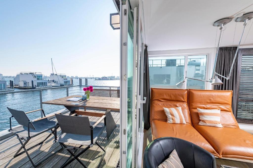 奥尔本尼兹Schwimmendes Haus 10 Grad Ost的船上的阳台配有沙发和椅子