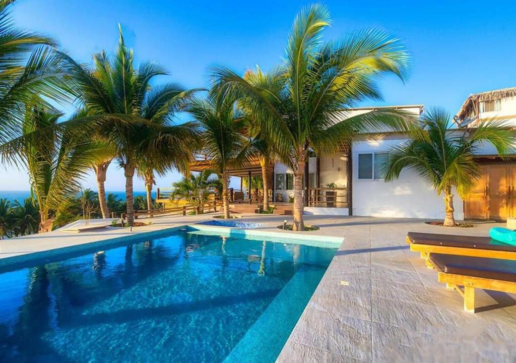 曼克拉Mar de Mancora Playa Las Pocitas的一座别墅前方的棕榈树游泳池