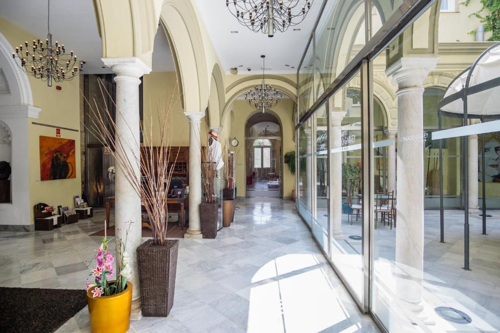 赫雷斯-德拉弗龙特拉加维宫酒店的一座带玻璃窗的大型建筑和大堂
