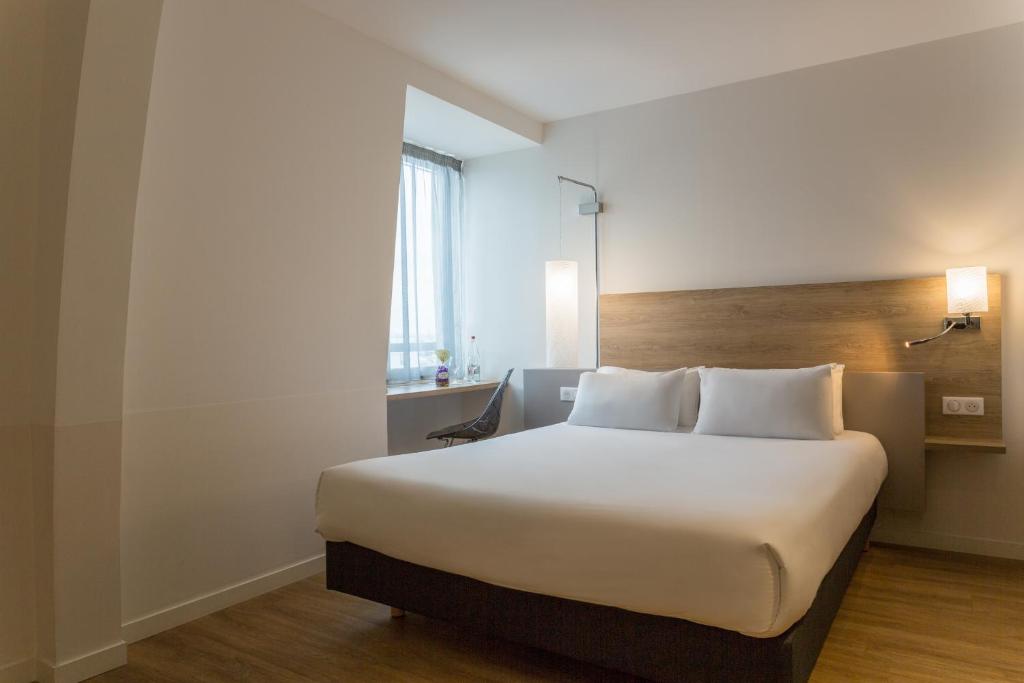 舍诺夫The Originals City, Hôtel Armony, Dijon Sud (Inter-Hotel)的一间卧室配有一张带白色床单的大床