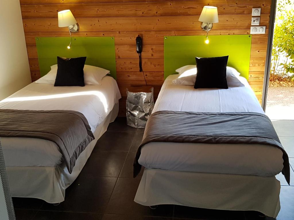 圣维尔巴斯生态汽车旅馆的配有绿色床头板的客房内的两张床