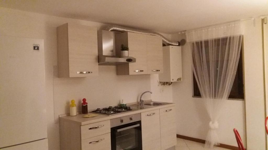 马帝斯兹罗Appartamento Casa Elettra的厨房配有白色橱柜和炉灶烤箱。