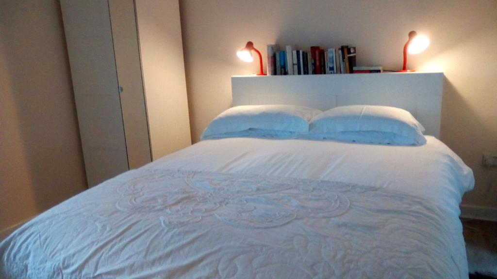 柯克纽顿Highfield Cottage的一间卧室配有白色的床和2个蓝色枕头