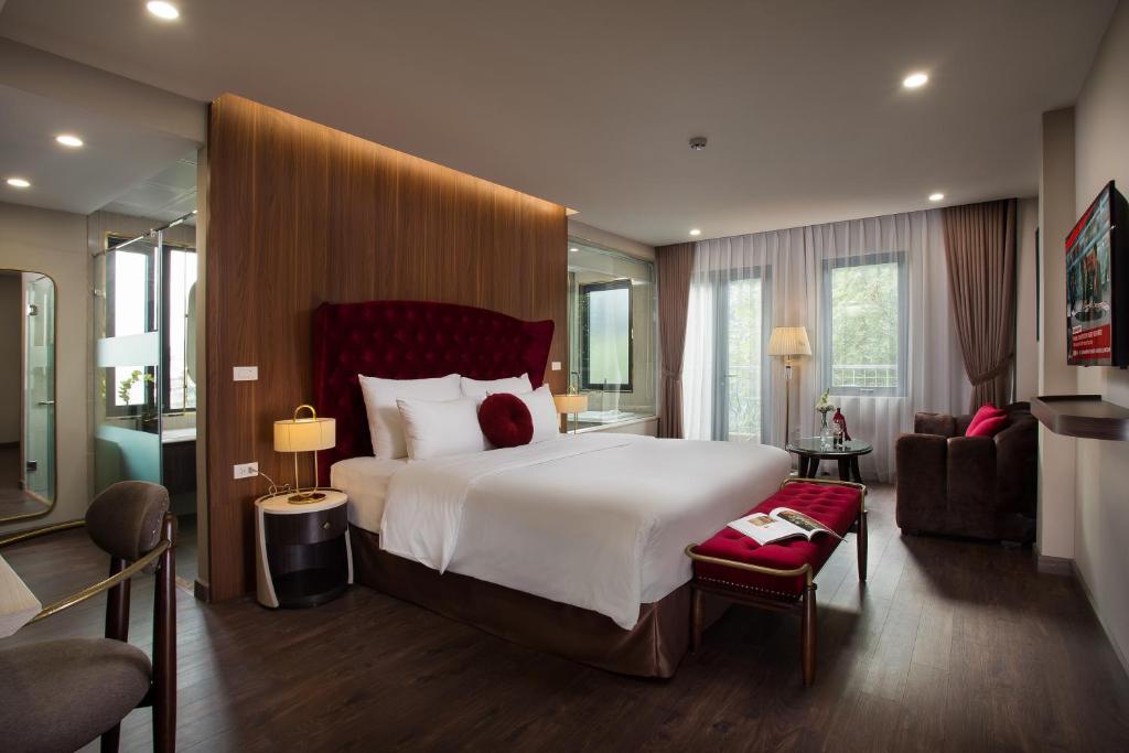 河内Hanoi L'Heritage Diamond Hotel & Spa的一间带大床的卧室和一间客厅