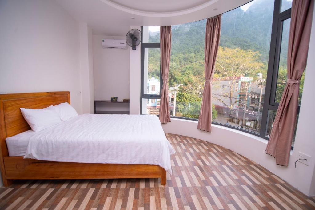 河江Long Hotel and motobike rental的一间卧室设有一张床和一个大窗户