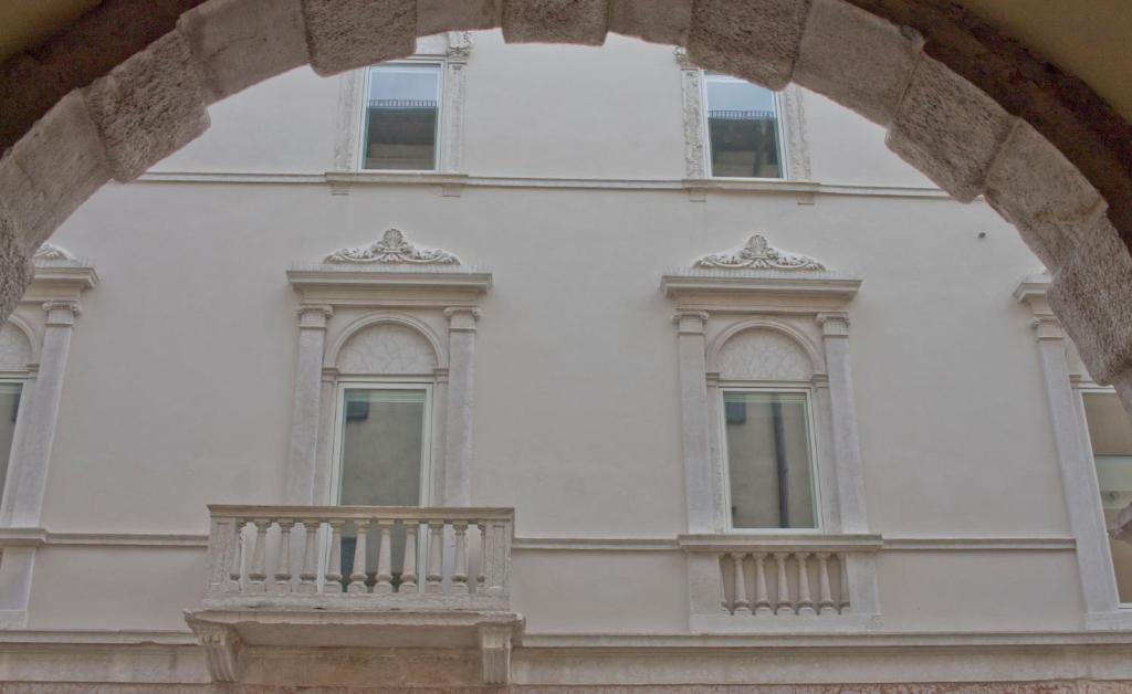 特伦托Casa Bacca apartments的白色的建筑,设有窗户和阳台
