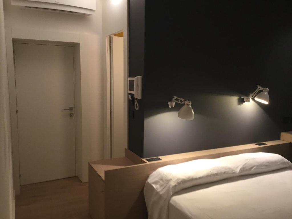 圣贝内代托-德尔特龙托Acquapazza Restaurant & Room的卧室配有一张床,墙上设有灯。