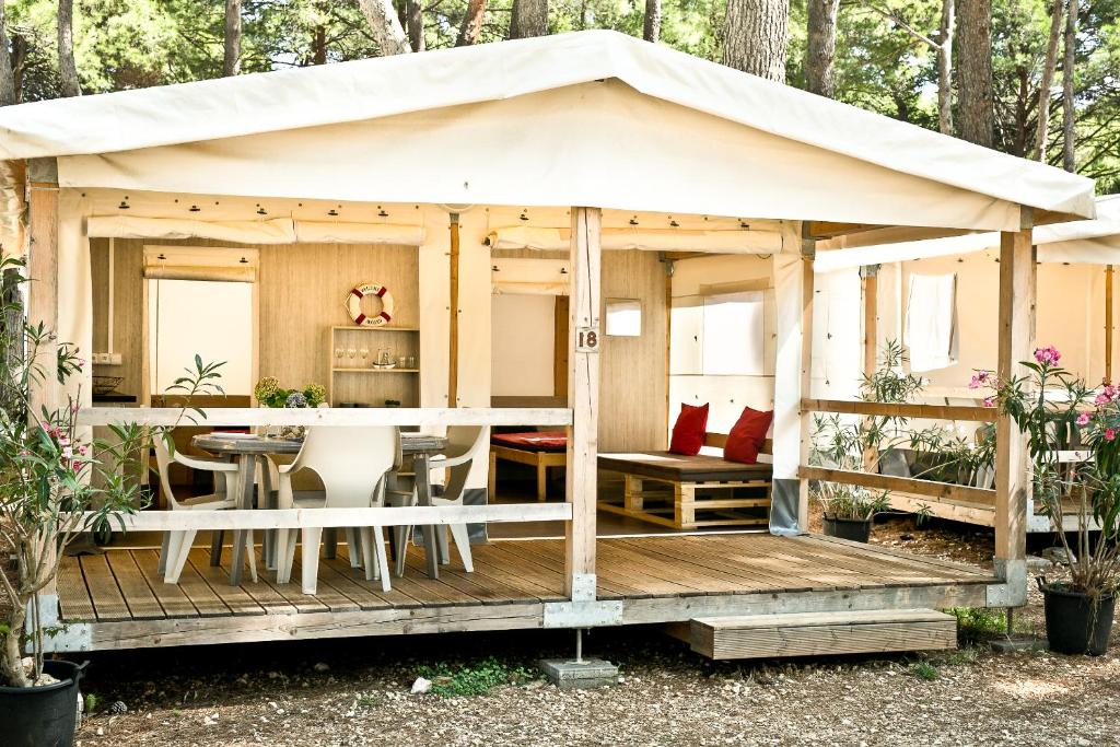 木洛希尼豪华露营地帐篷|洛希尼岛|坎普曲喀特的木制甲板上配有桌椅的凉亭