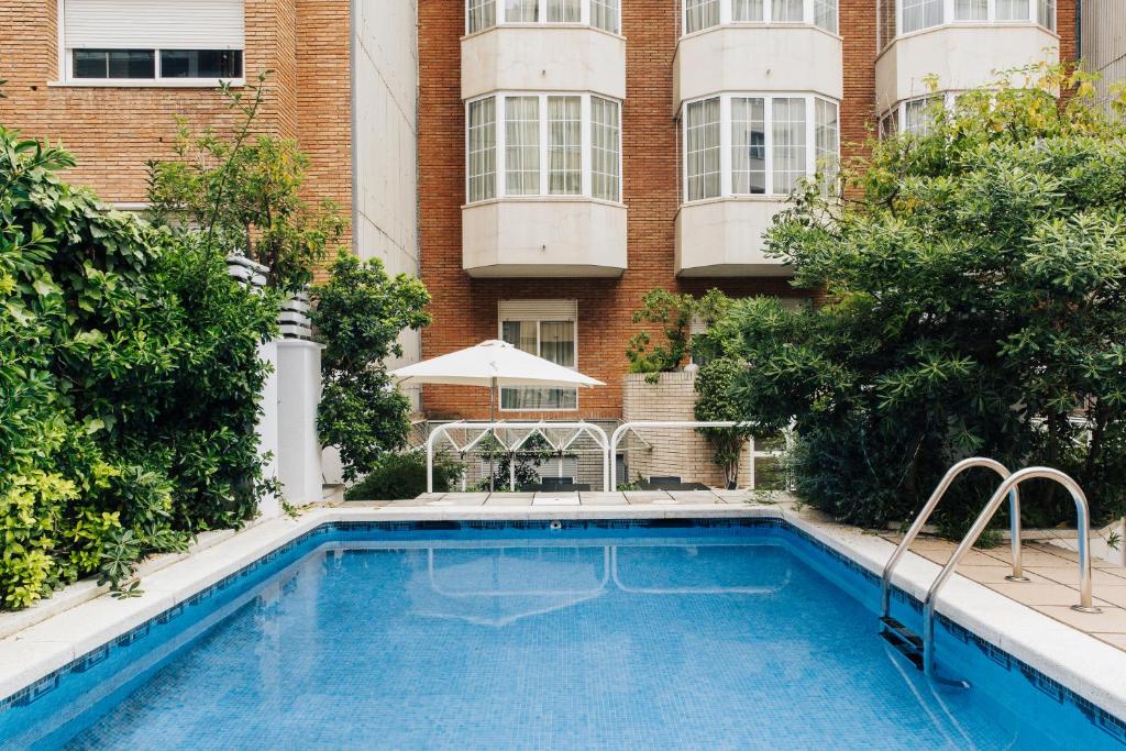 巴塞罗那Hotel Gran Derby Suites, a Small Luxury Hotel of the World的大楼前的游泳池