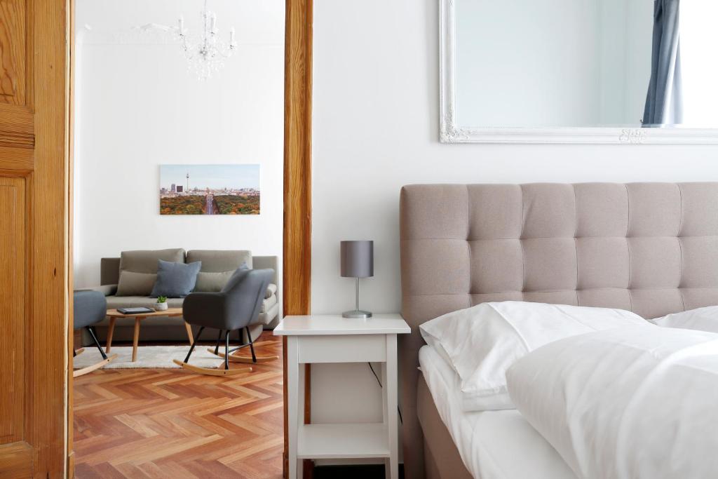 柏林Apartment KATZBACH - Cozy Family & Business Flair welcomes you - Rockchair Apartments的一间卧室配有一张床、一张沙发和一张桌子