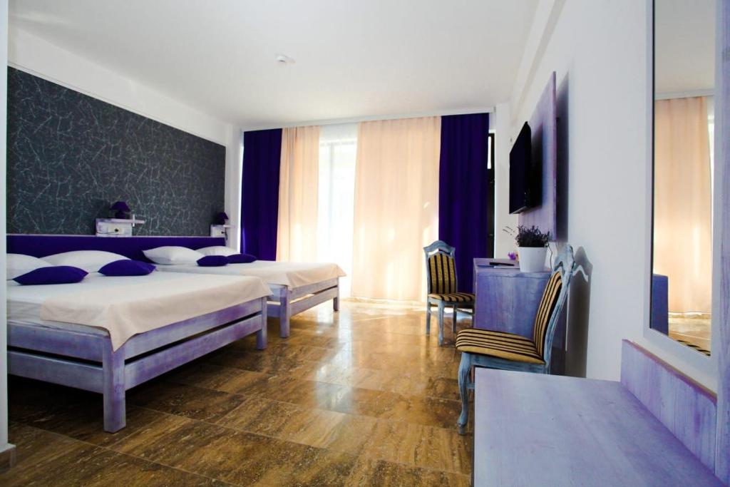 北马马亚-讷沃达里Lavender Villa的一间卧室配有两张床和一张桌子及椅子