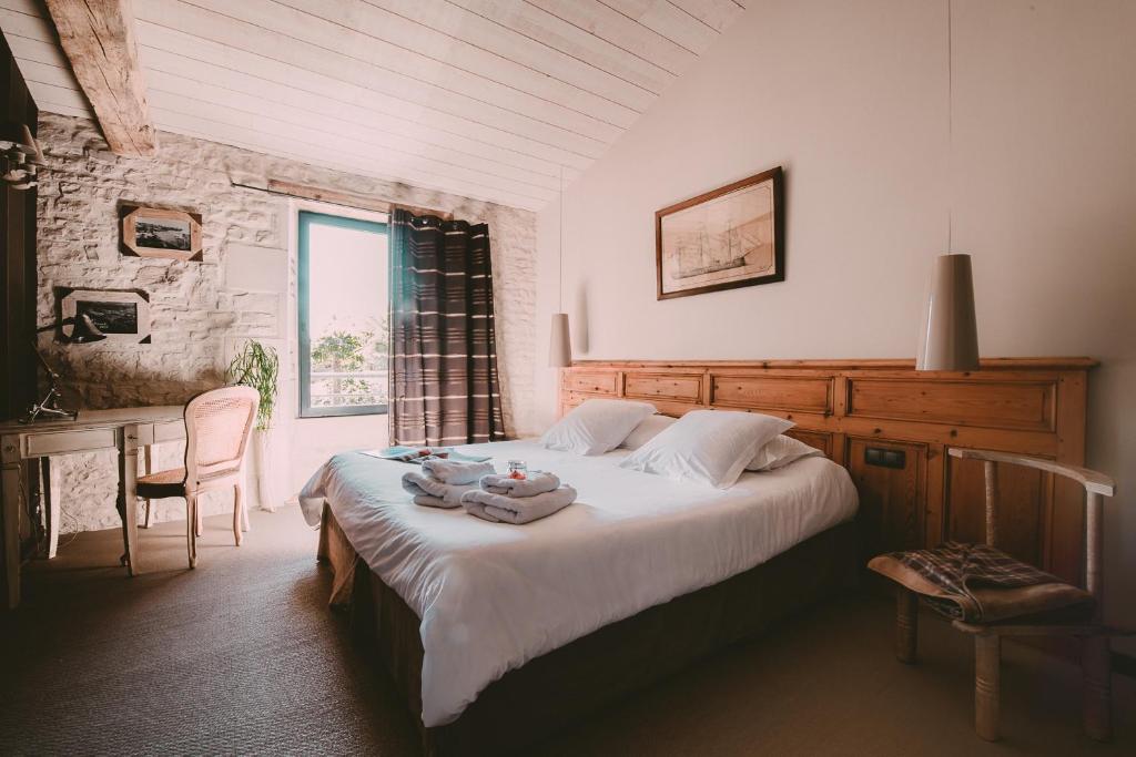 Marsilly阳光下长凳住宿加早餐旅馆的一间卧室配有一张床、一张桌子和一个窗户。