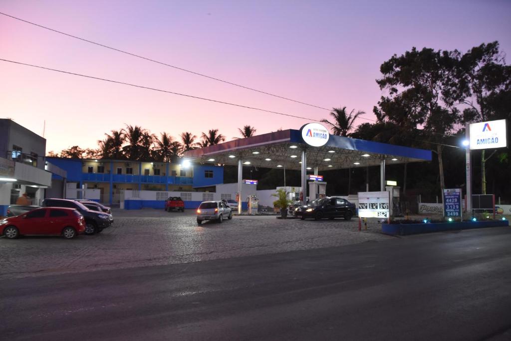 São Gonçalo do AmarantePousada e Posto Amigão的加油站,停泊在停车场的汽车