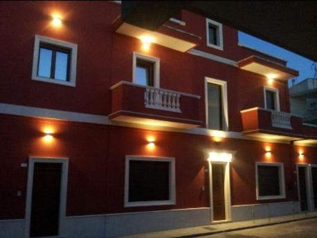 马利耶Mediterraneo B&B的一座红色的大建筑,旁边灯火通明