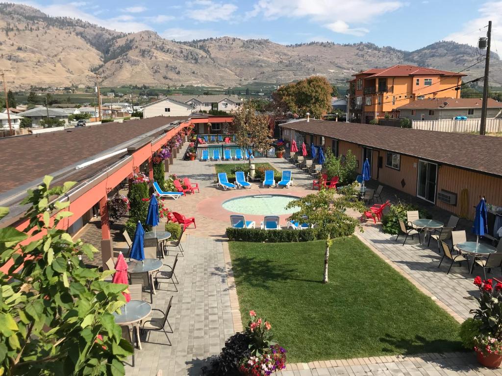 奥索尤斯Sahara Courtyard Inn & Suites Osoyoos的享有带游泳池和椅子的度假村的顶部景致