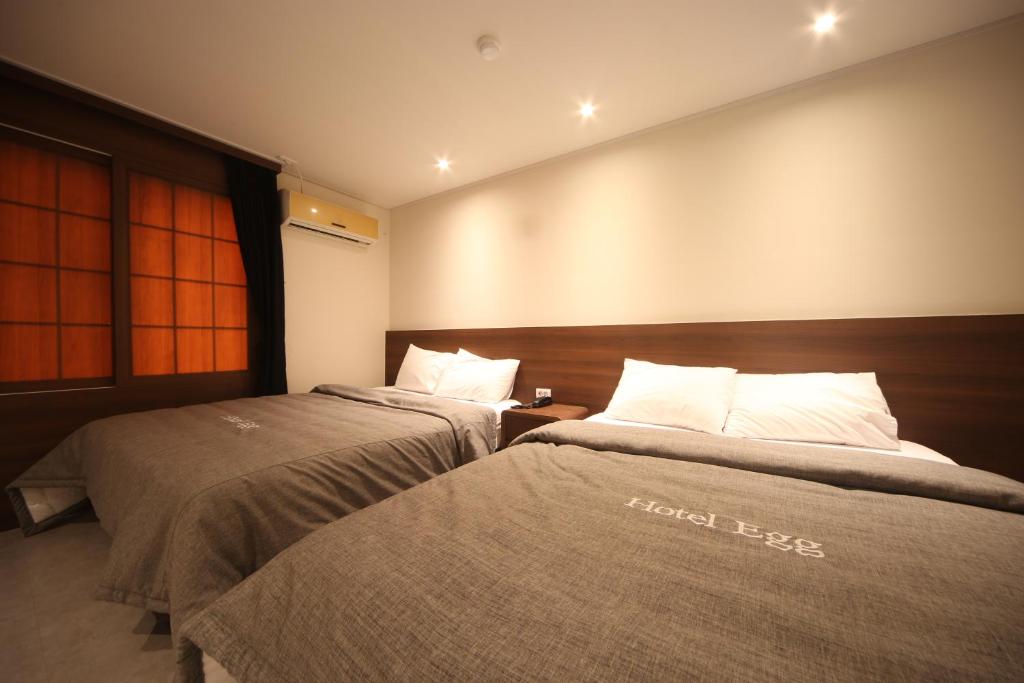 釜山Hotel Egg的酒店客房的两张床