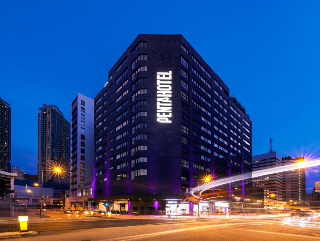 香港Pentahotel Hong Kong, Tuen Mun的一座高大的黑色建筑,上面写着酒店字