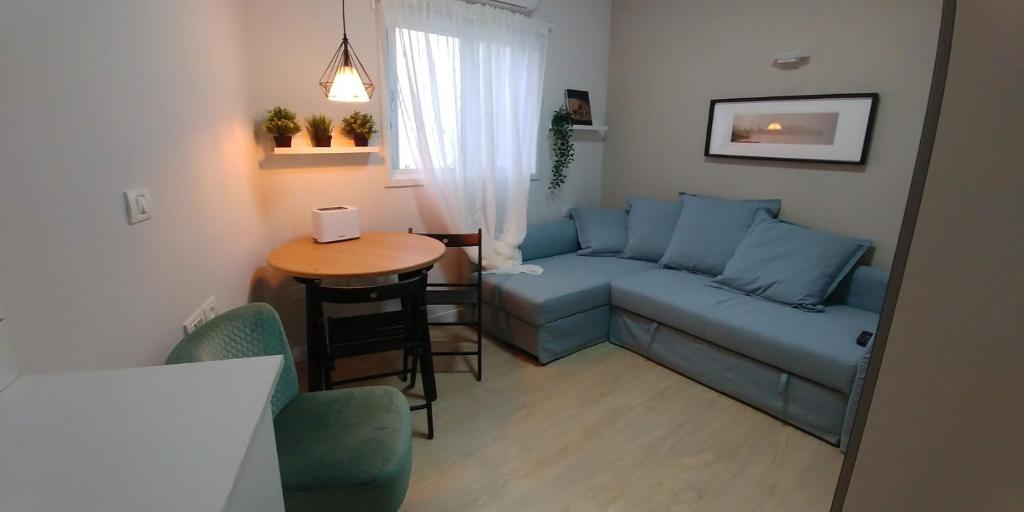 内坦亚Ramat Poleg, walk to beach的客厅配有蓝色的沙发和桌子