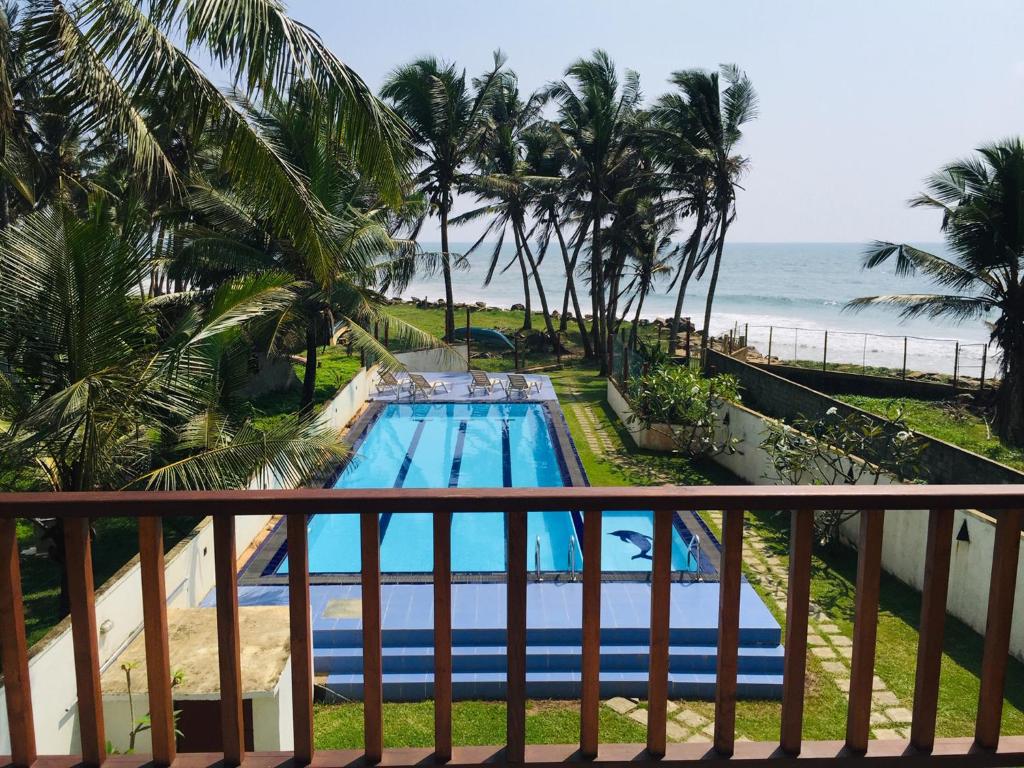 高尔Villa Ocean Dew - Beach Front的从度假村的阳台上可欣赏到游泳池的景色