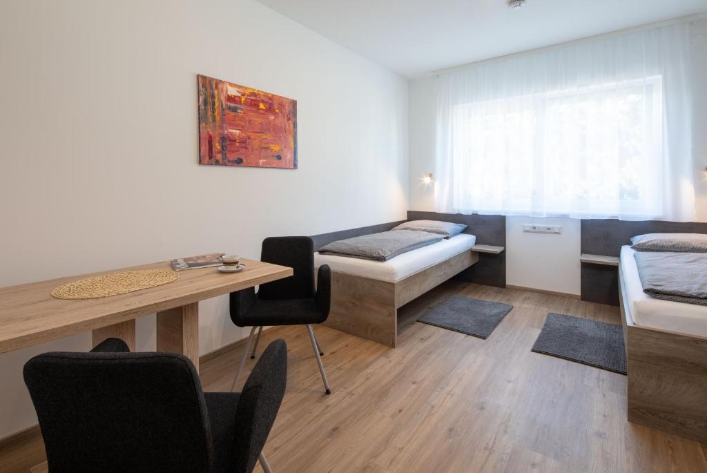 克雷姆斯明斯特Haus an der Krems的客房设有一张床、一张桌子和一张桌子。