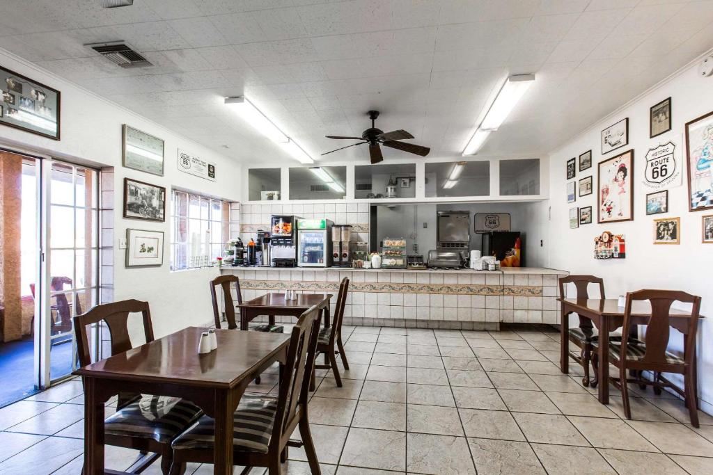 金曼Rodeway Inn Kingman Route 66的一间有桌椅和厨房的餐厅