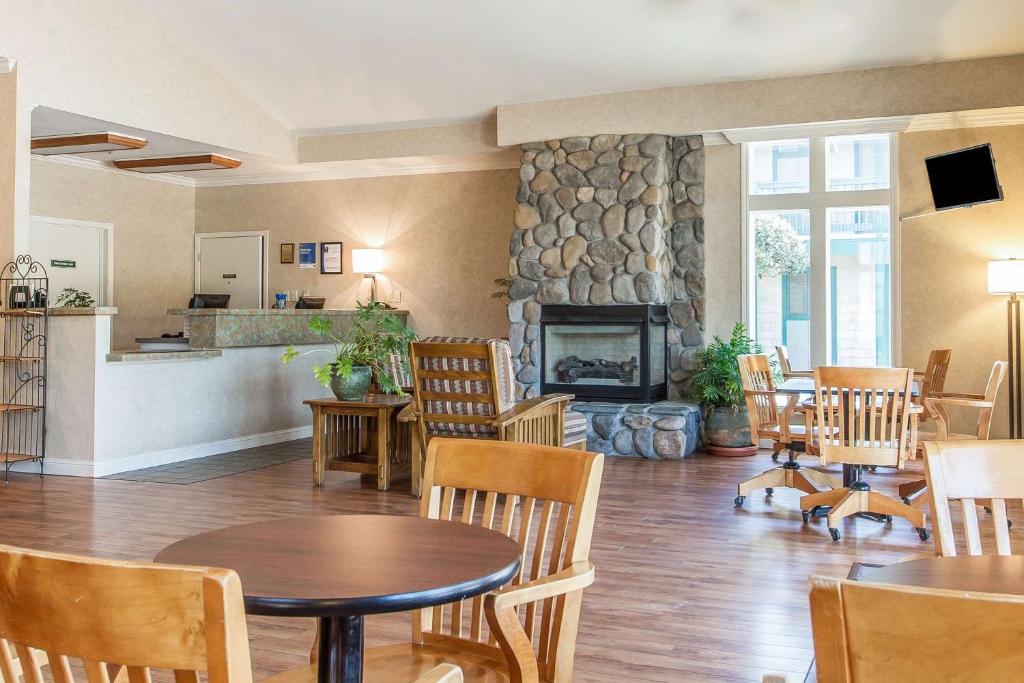 半月湾Quality Inn Half Moon Bay-Miramar Beach的客厅配有桌椅和壁炉