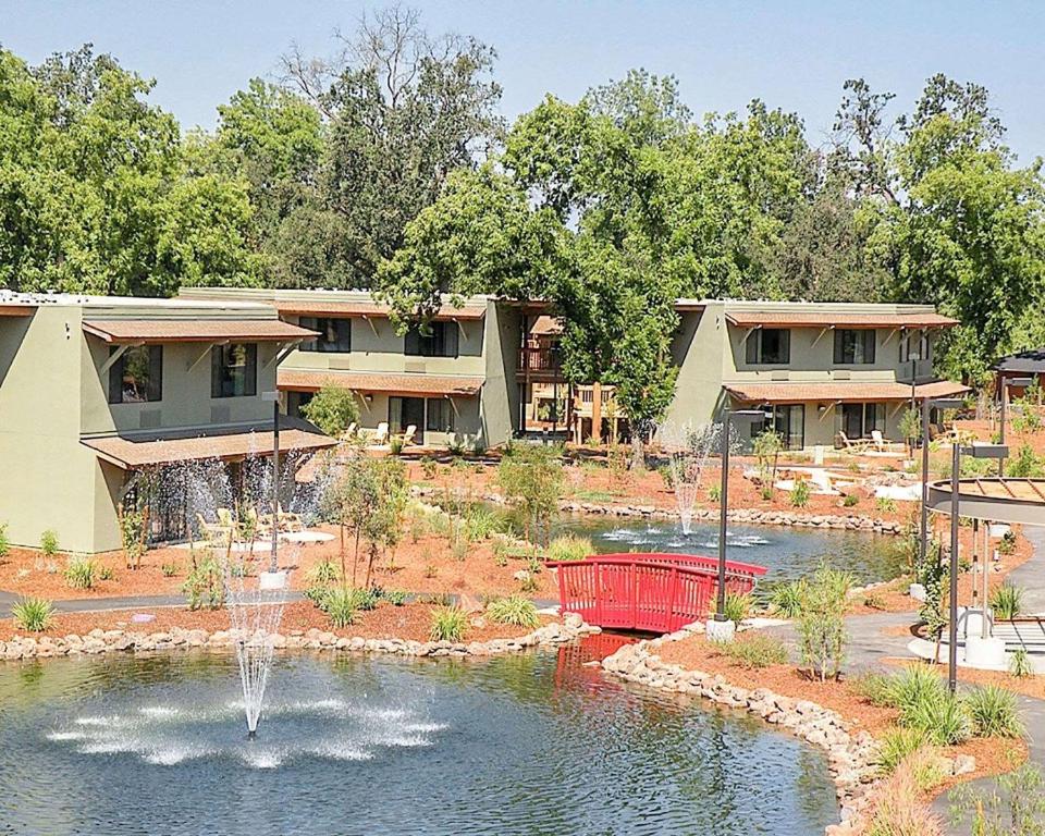 安德森Gaia Hotel & Spa Redding, Ascend Hotel Collection的池塘中央有喷泉的房子
