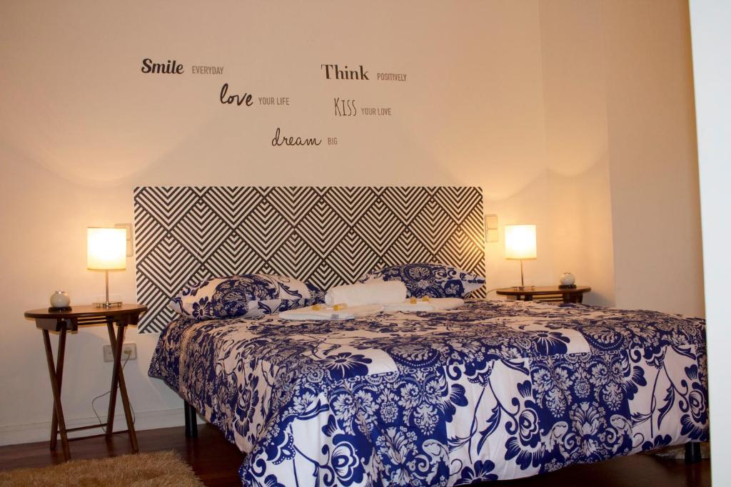 菲盖拉-达福什Casino Figueira Prime Apartment的一间卧室配有一张带两盏灯的蓝色和白色的床。
