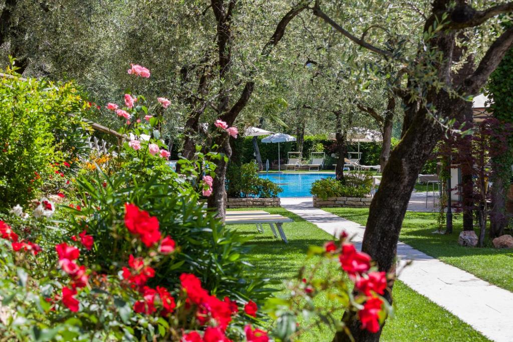 托尔博莱托尼尔大陆酒店的一座种有红色鲜花的花园和一个游泳池
