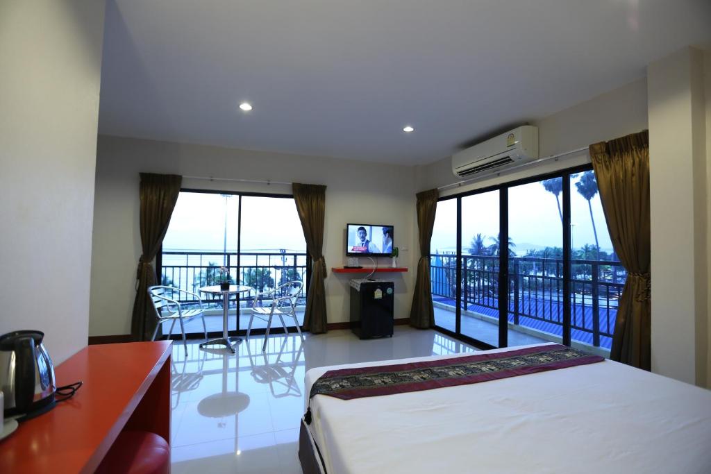 乔木提恩海滩阳光酒店的一间卧室设有一张床,阳台配有电视。