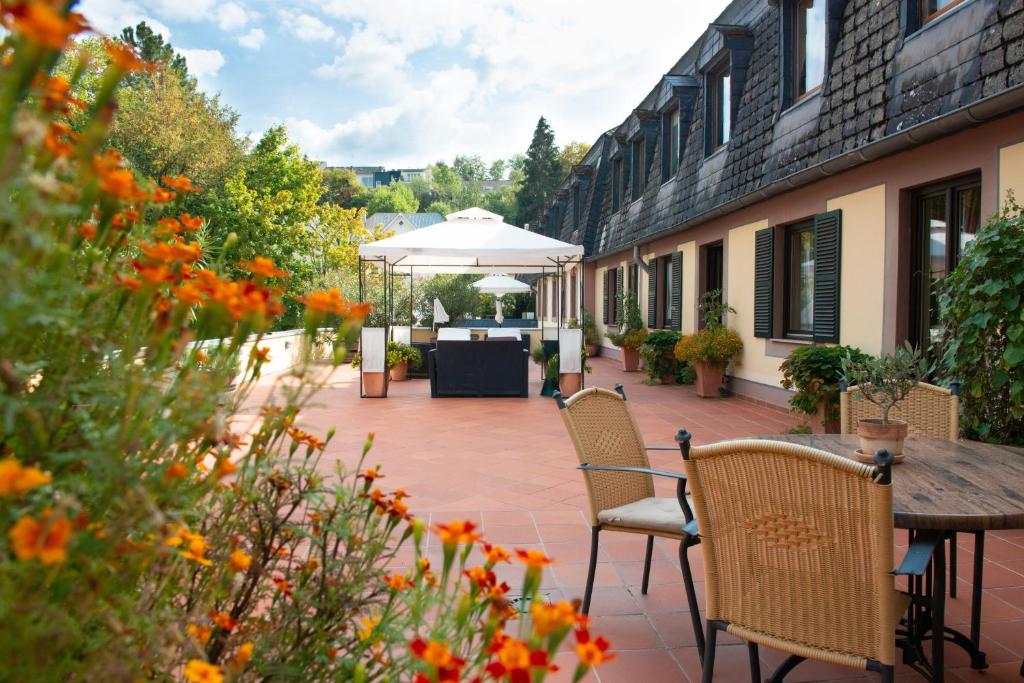 特里尔贝勒索斯伽藤酒店的庭院配有桌椅和遮阳伞。