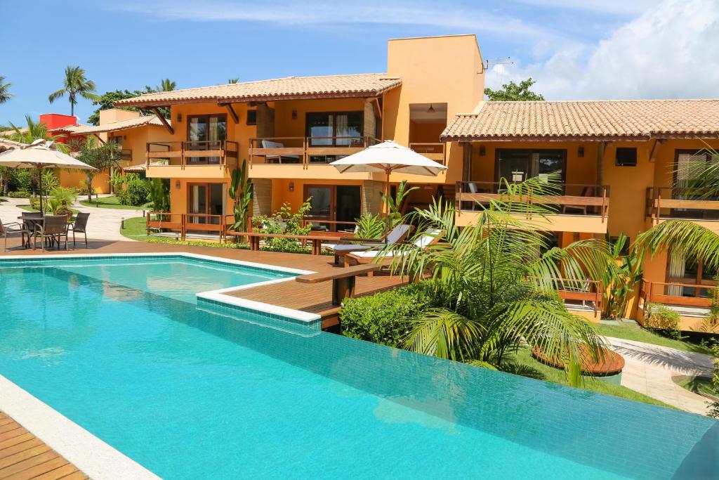 阿拉亚尔达茹达Cores do Arraial Residence Hotel的别墅前设有游泳池