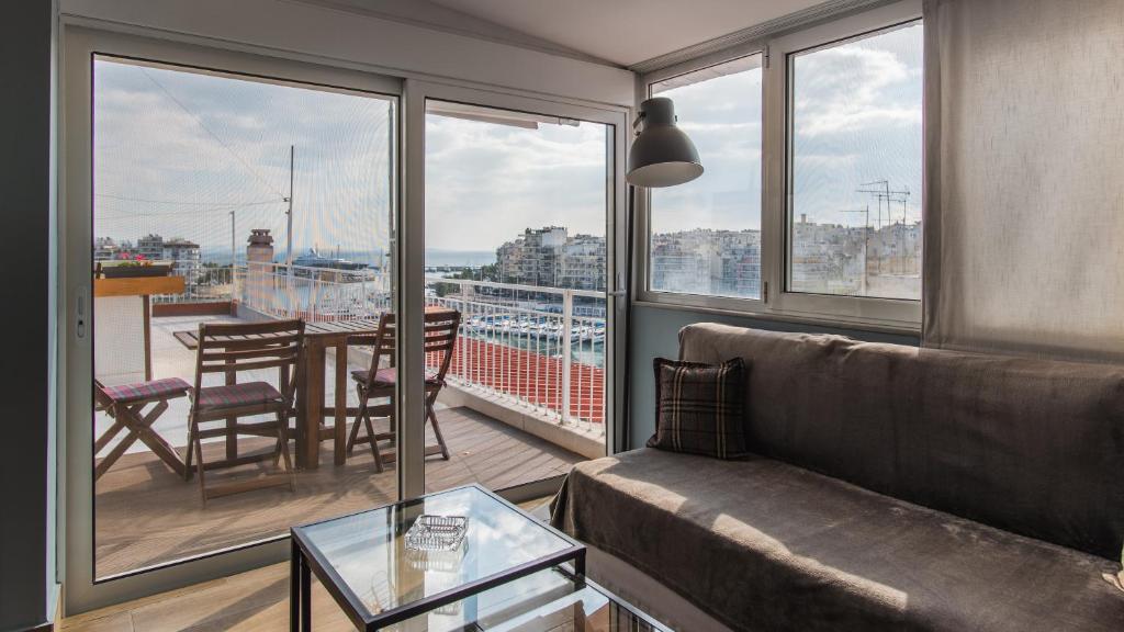 比雷埃夫斯Piraeus Apartment with Endless View的客厅配有沙发和阳台桌子