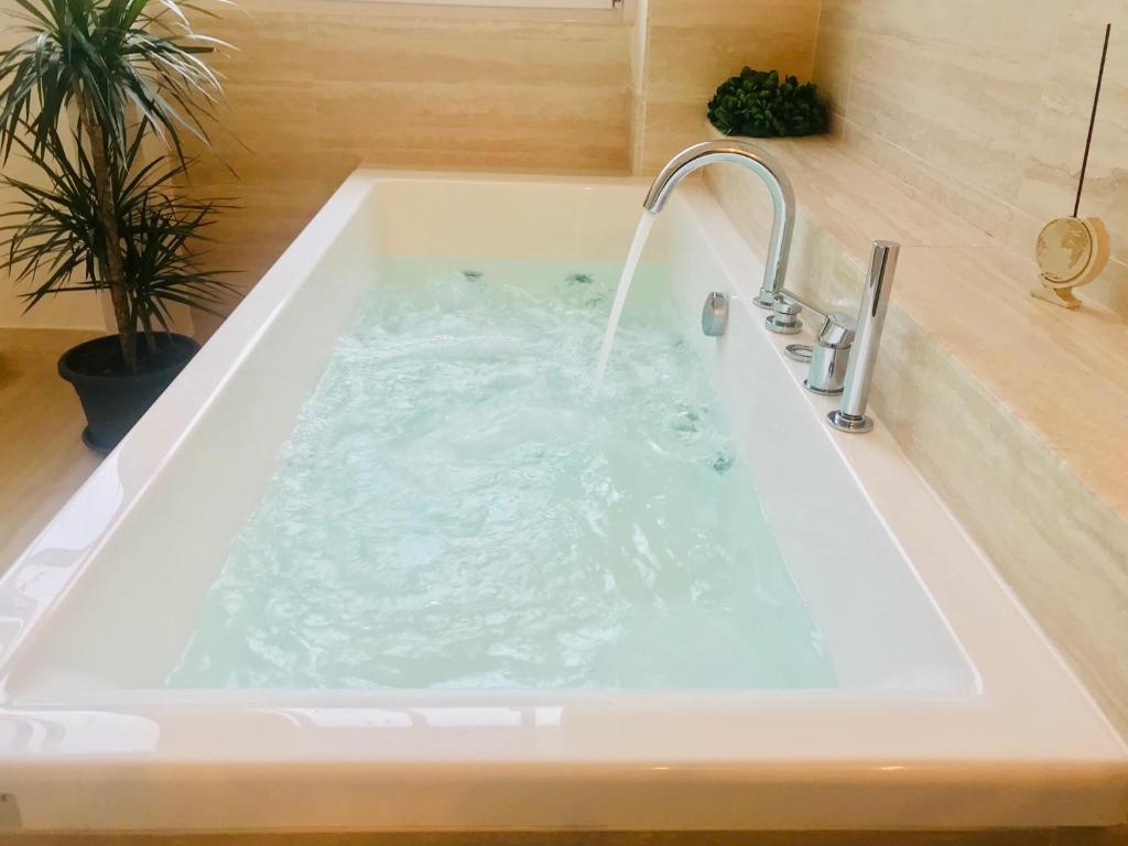 卡利亚里Bluemoon Sardinia的装满水的浴缸,配有水龙头