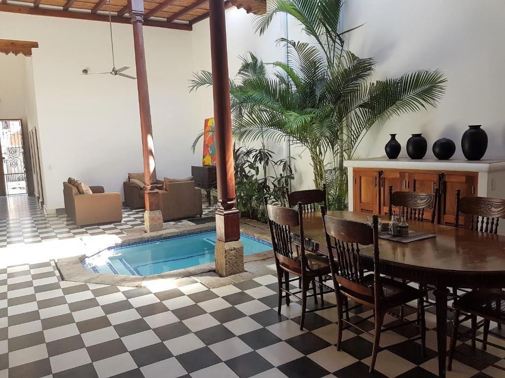 格拉纳达Lovely new-build colonial house with plunge pool的客厅设有桌子和游泳池