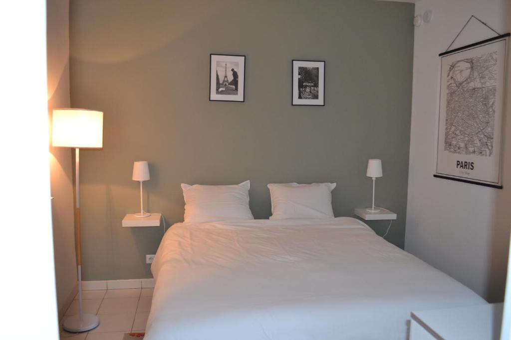 默东Meudon : idéal pour séjour à Paris的一间卧室配有一张带两盏灯的大型白色床。