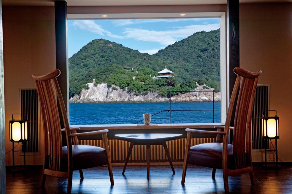 福山米格瓦特欧驰卡慈酒店的一张桌子和椅子,享有海景