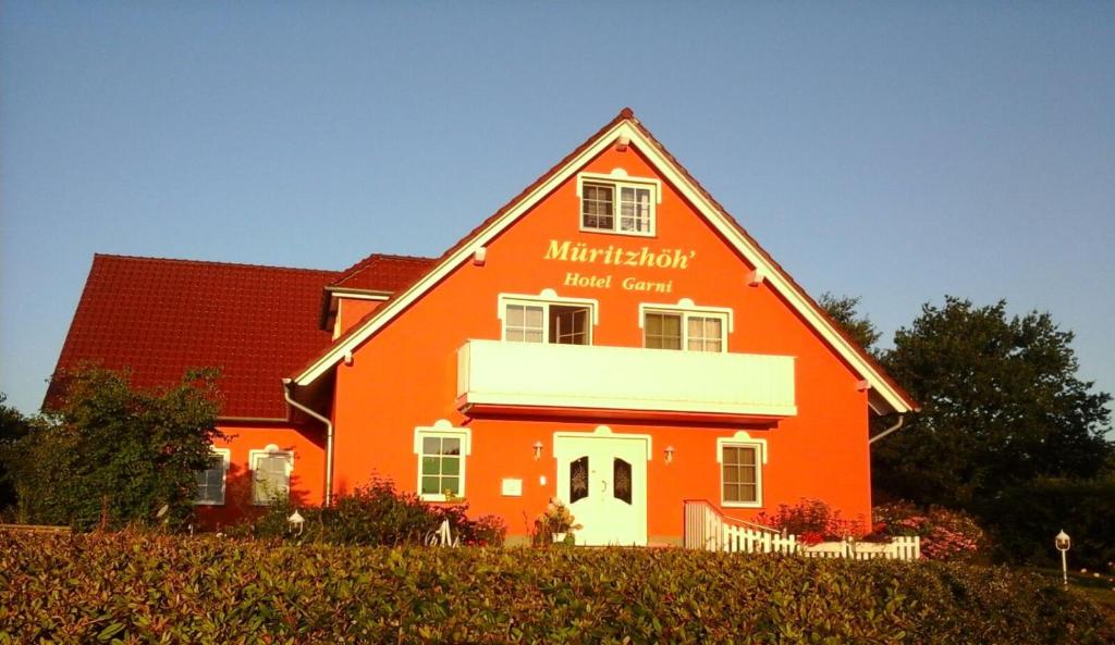 雷希林木里卓酒店的一座大型橙色房子,上面有标志