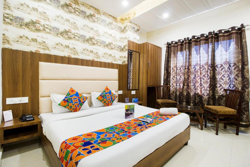 阿姆利则FabHotel Royal Villa Hussainpura Chowk的酒店客房带两张床和一张桌子以及椅子。