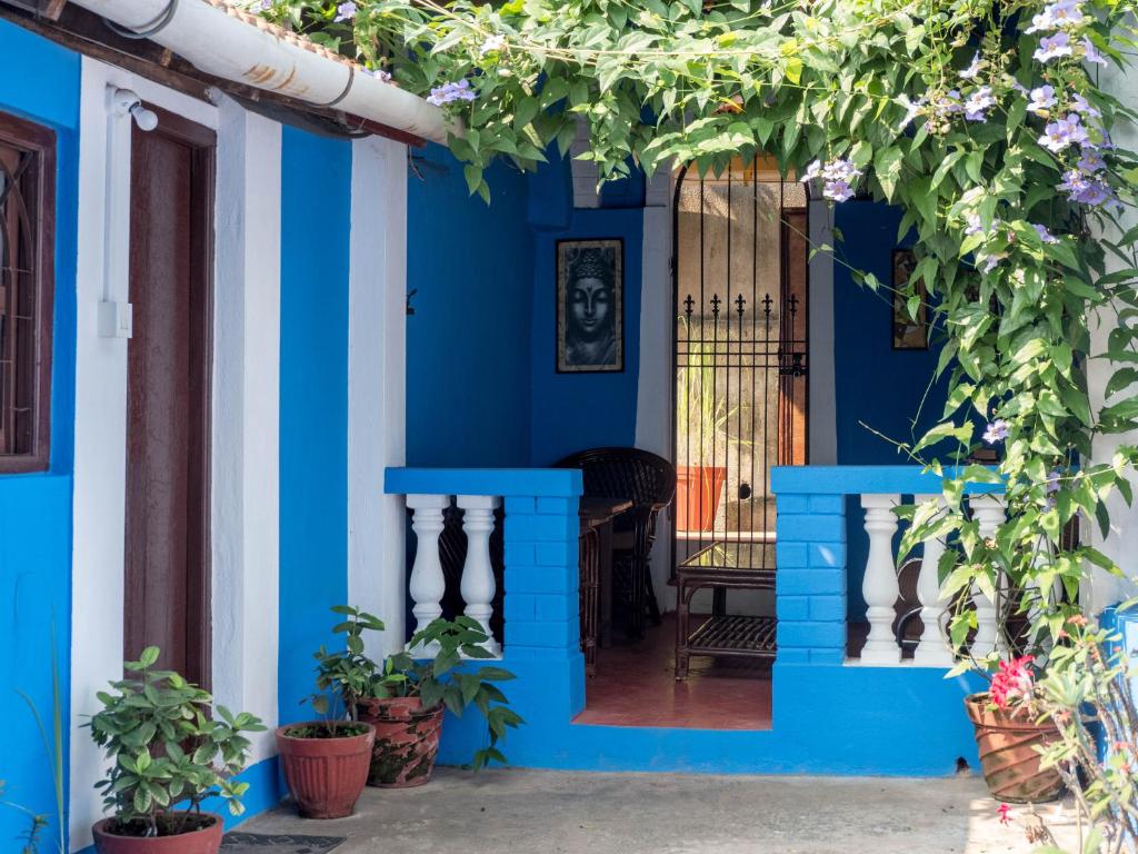 帕纳吉卡特恩别墅住宿加早餐旅馆的一座带门和植物的蓝色房子