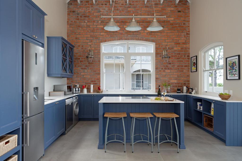 开普敦Le Vine Constantia的厨房配有蓝色橱柜和砖墙