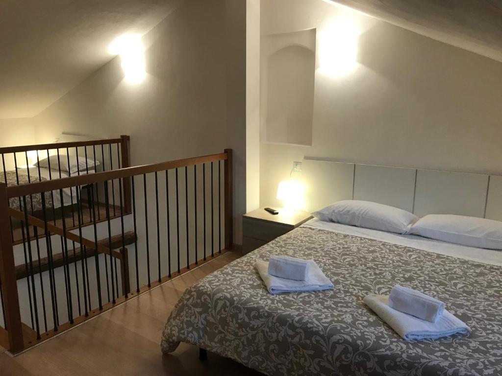 费拉拉APPARTAMENTI del DUCA的一间卧室配有一张床,上面有两条毛巾