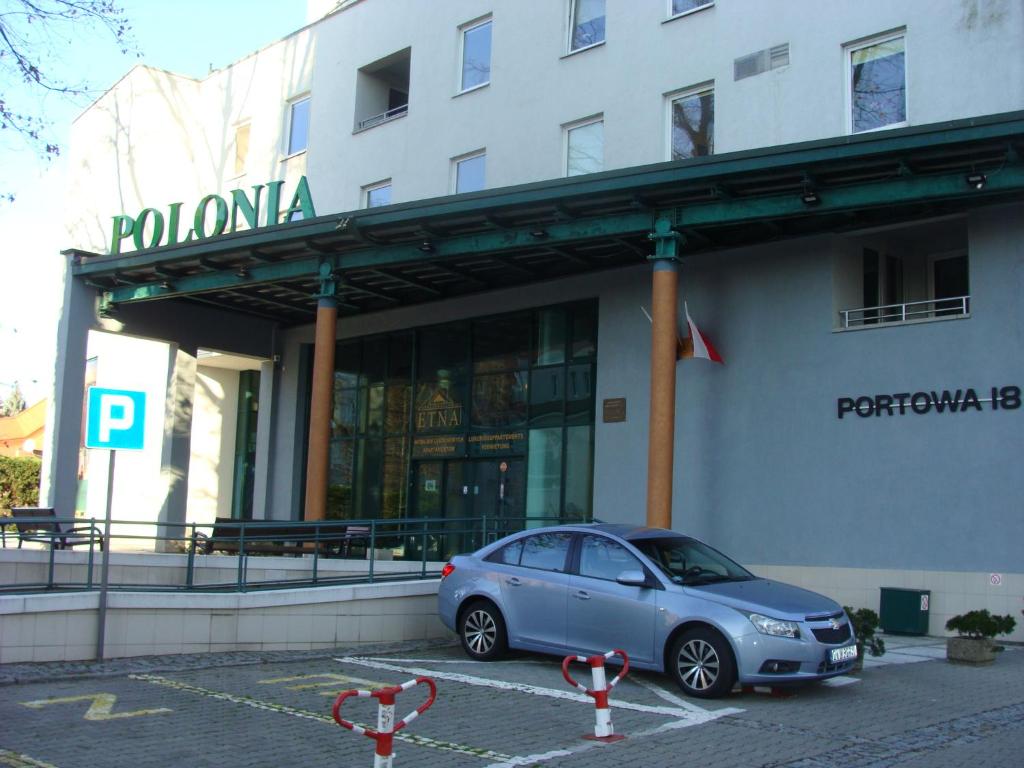 科沃布热格Kołobrzeg-hotel Polonia apartament 207的停在大楼前的蓝色汽车