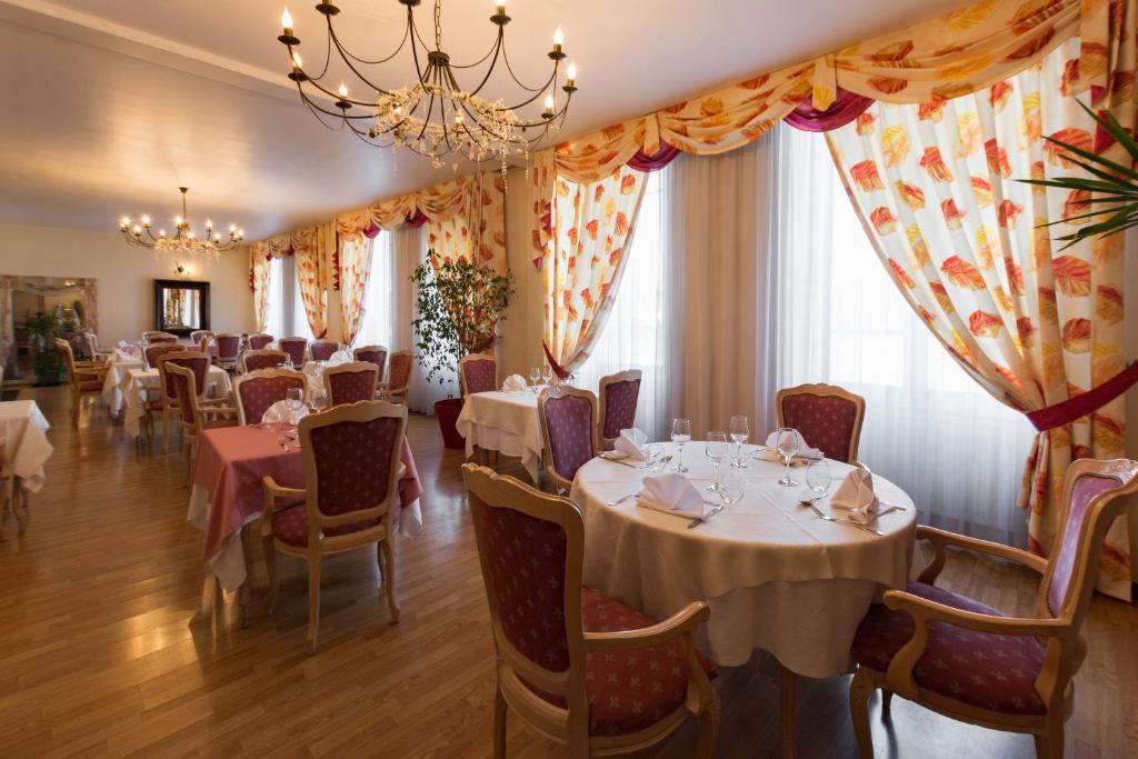 圣迪济耶尚巴尼酒店的一间带桌椅和吊灯的用餐室