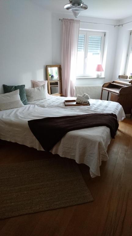 AlfterTausendschön的一间卧室配有一张带白色床单的大床