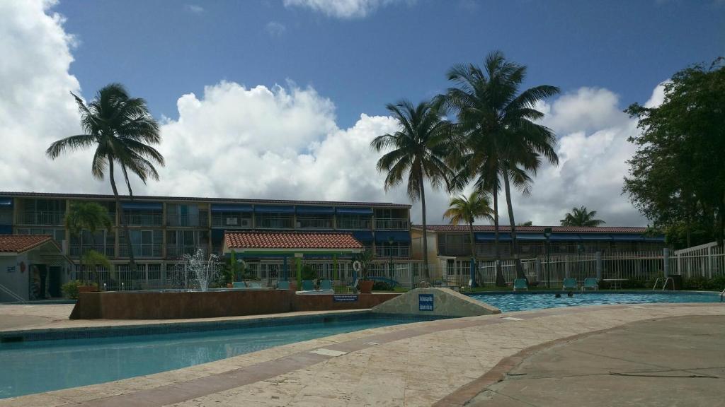 多拉多Dorado Beach Condo的一座带游泳池的度假村,位于一座建筑前